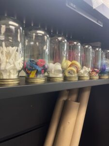 Bits and bobs collected in a row of jars on a shelf